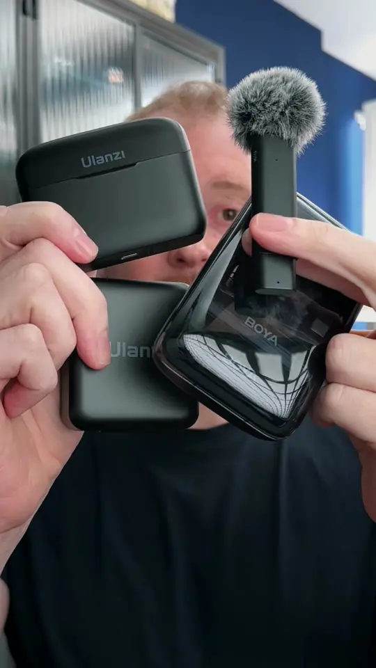 Tiago Oliveira segurando quatro microfones de lapela sem fio, na gravação de um comparativo